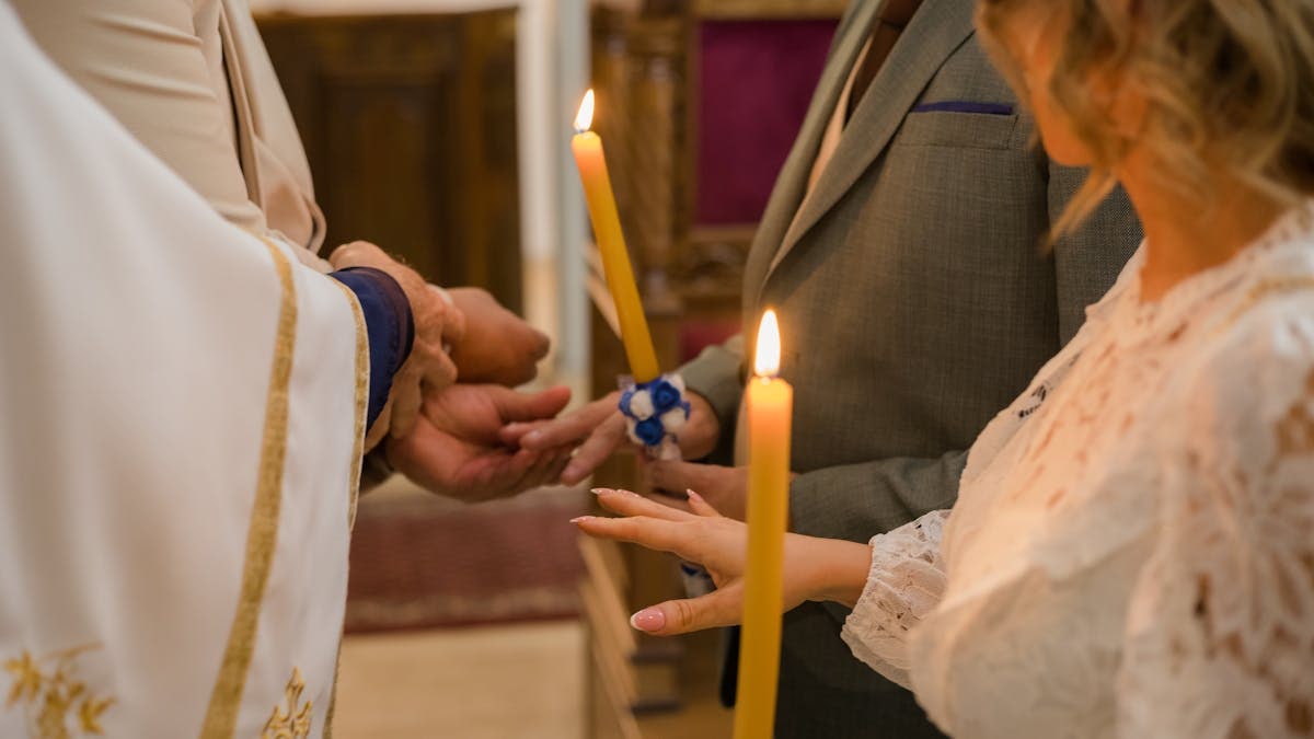 Close-up of traditional Serbian Orthodox wedding with candle lighting ritual.